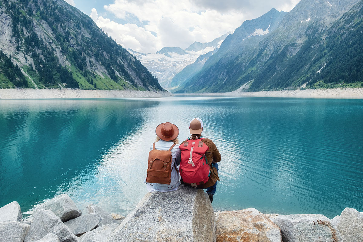 couple sitting in front of a lake who have used financial tips for traveling